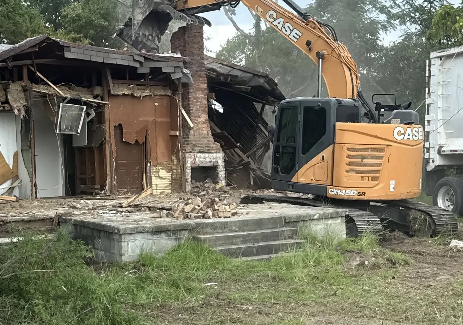 Dirt Cheap excavator taking down a house on a demolition job